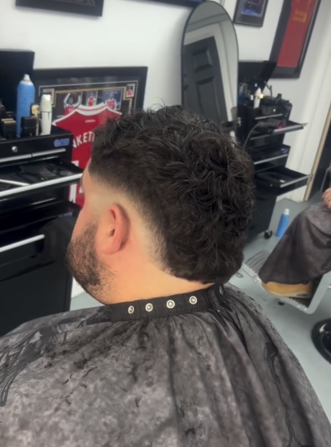 Curly textured haircut with a clean taper